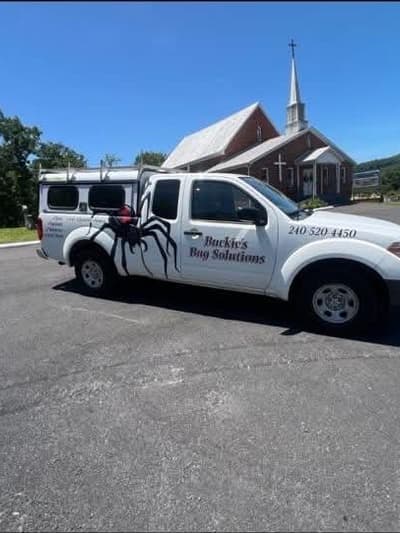 The lettered Buckie's Bug Solutions truck parked on a job in the Eastern Panhandle